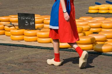 Ragazza, con abiti tradizionali e zoccoli di legno, che si esibisce durante il mercato del formaggio della città di Alkmaar