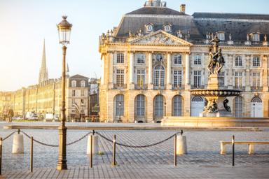 Lampione nella città di Bordeaux sulla destra una fontana con dietro un edificio storico